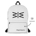A white backpack with a black geometric logo on the front, a large zippered front pocket printed with 'Wing & Wood Co.', and a black top handle.