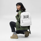 Person wearing a white backpack with a logo, posing against a plain background