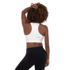 Person wearing a colorful striped sports bra and black leggings on a white background