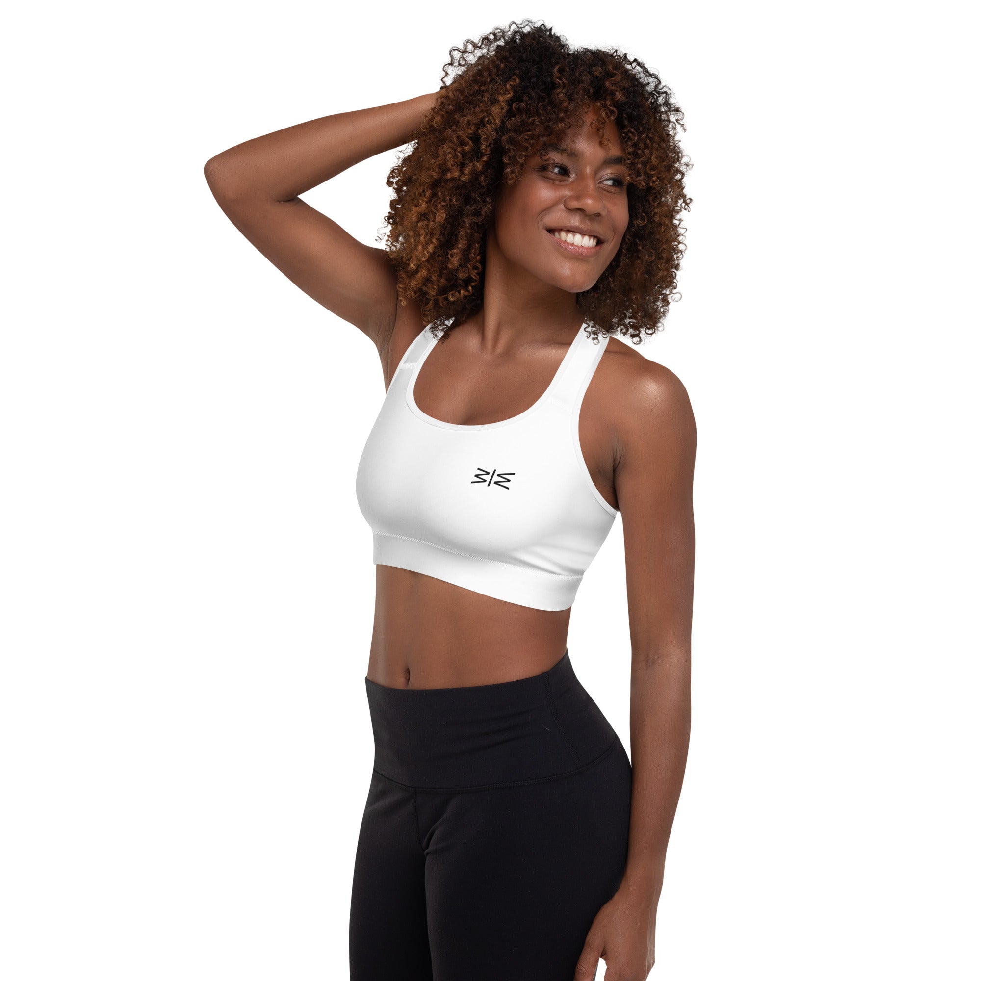 Woman wearing a white sports bra and black leggings on a white background