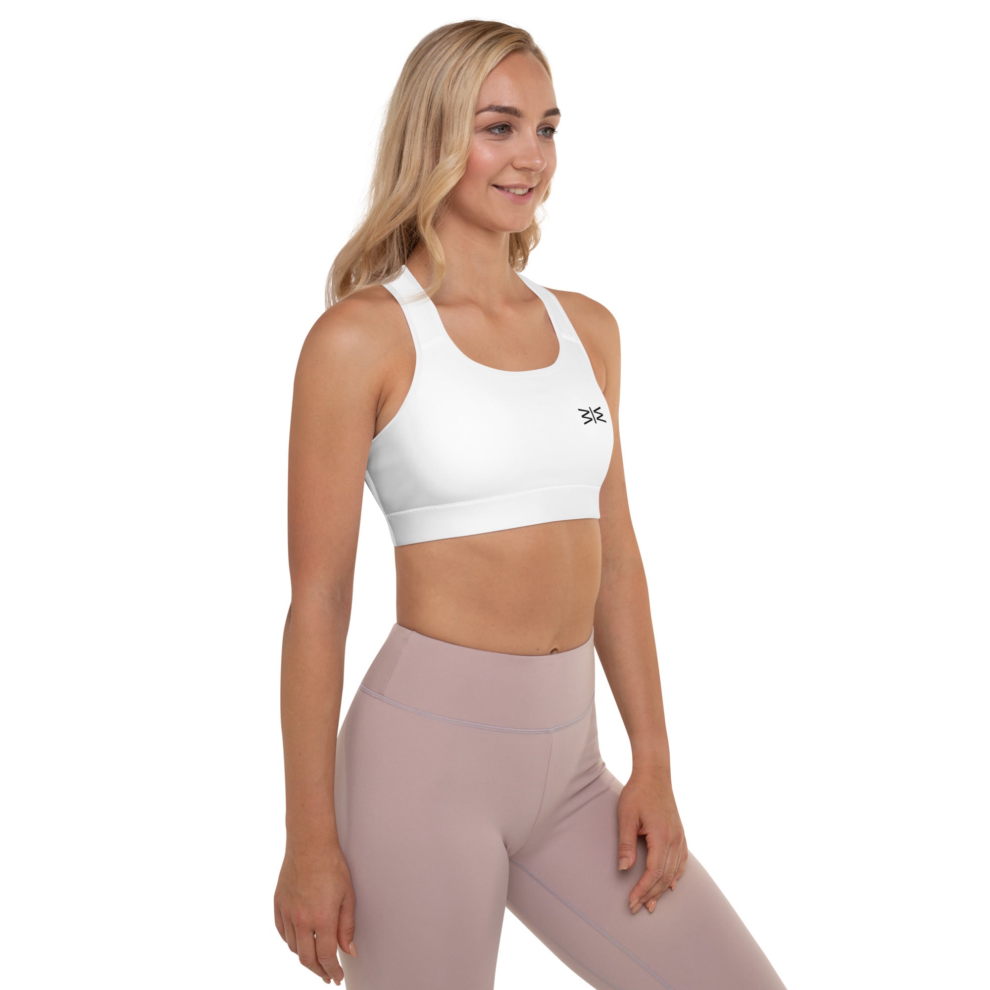 Woman wearing a white sports bra and pink leggings on a white background