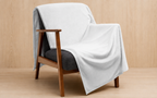 A light gray throw blanket draped over a mid-century modern wooden armchair with a dark gray upholstered seat, set against a light wood-paneled background.