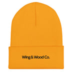 A bright yellow ribbed knit beanie hat with a folded cuff and the text 'Wing & Wood Co.' printed in black on the front, shown against a plain white background.