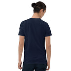 A man viewed from behind wearing a navy blue short-sleeve t-shirt with a small white logo on the left sleeve, set against a plain white background.