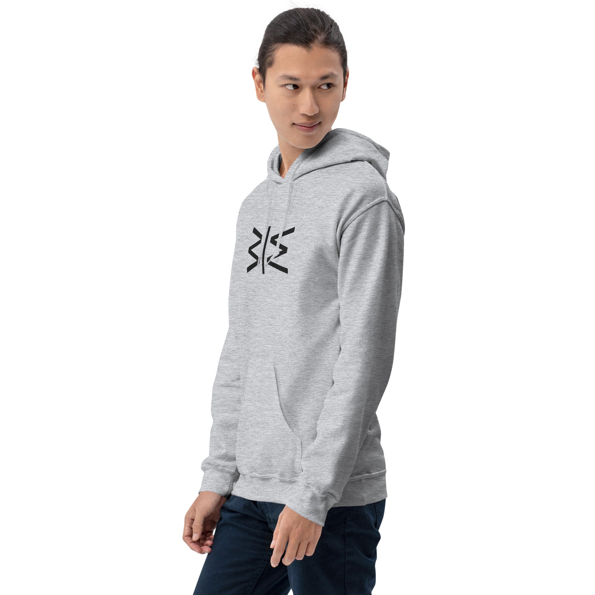 A man wearing a light gray heather pullover hoodie with a colorful graphic print on the chest, paired with dark blue jeans, photographed against a solid white background.