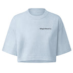 A light blue cropped short-sleeve t-shirt with 'Wing & Wood Co.' printed in black on the left chest, displayed on a solid white background.